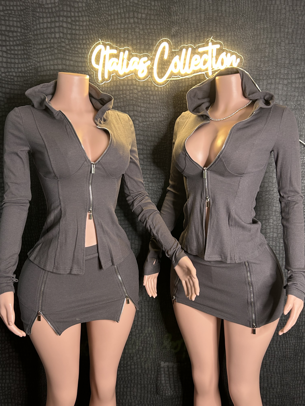 Two mannequins wearing matching gray outfits with a 'Italia Collection' sign above.